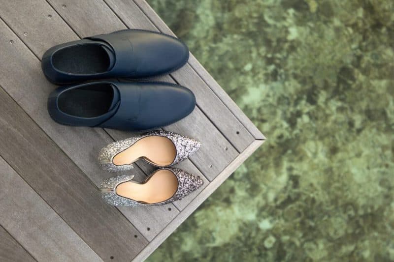 jenis sepatu unisex pria dan wanita, sepatu heels dan slip on di atas meja kayu dengan background lumut di air