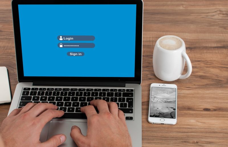 login username dan password laptop, meja kerja dengan laptop cangkir dan handphone serta tangan yang sedang mengetik, cara mengubah atau mengganti username shopee