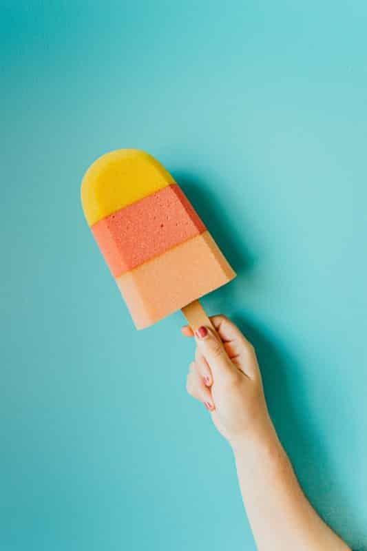 foto keren untuk profil whatsapp instagram telegram tiktok facebook line aestetik estetik tangan memegang es krim stik warna warni di atas latar biru polos