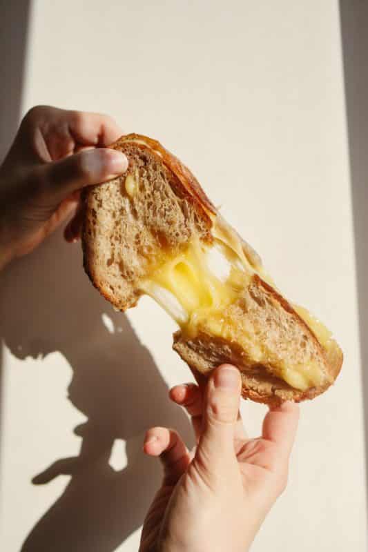 foto keren untuk profil whatsapp instagram telegram tiktok facebook line aestetik estetik tangan memegang dan mearik roti keju meleleh di bawah sinar matahari